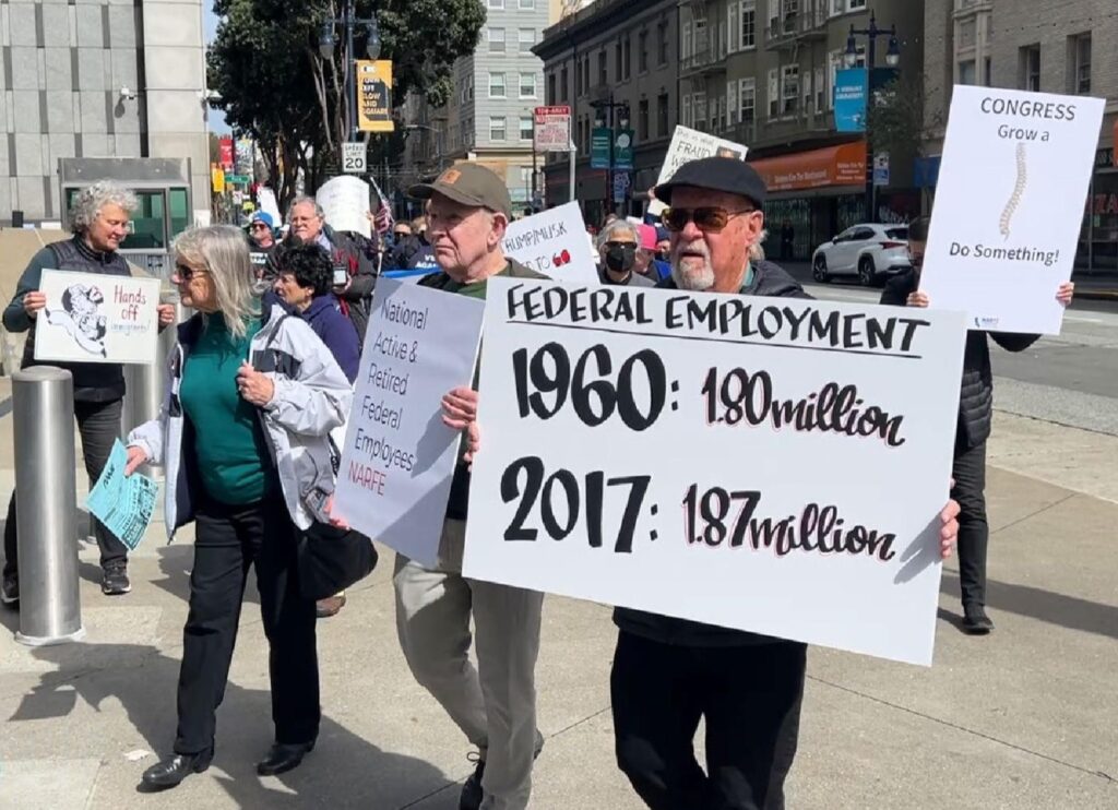 people holding signs and walking on sidewalk