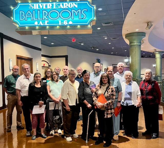 group of 16 people standing under while letters on turquoise sign for Silver Baron Ballrooms