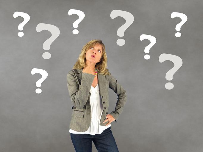woman looking upward at a lot of question marks