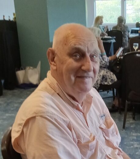 man wearing pink shirt seated