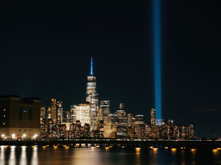 New York City skyline at night showing the blue Tribute in Light rising from the site of the World Trade Center.