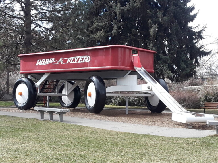 Oversized red wagon functions as children's slide.