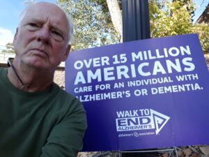 Man in front of sign for Walk to End Alzheimer's.