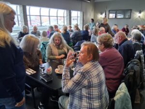 Numerous people sitting around dining tables.