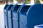 Four blue postal service mail boxes.