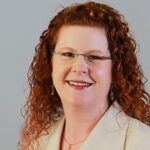 woman with red hair and glasses