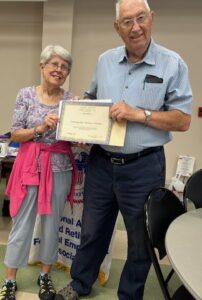 Picture of Chapter President Kenneth Overhults presenting Distinguished Members award to Vickie Batzka, Chapter Secretary.