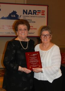 Two women holding a plaque