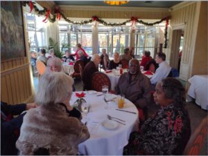 Picture of People sitting around the table. 2023 Holiday Luncheon at Mere Bulles Restaurant
