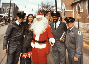 Four Letter Carriers standing with Santa at Christmas Parade.
