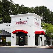 White building with raised entrance with awnings over doors.