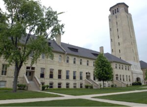 section of limestone three-story building connected to ten-story tower on the right