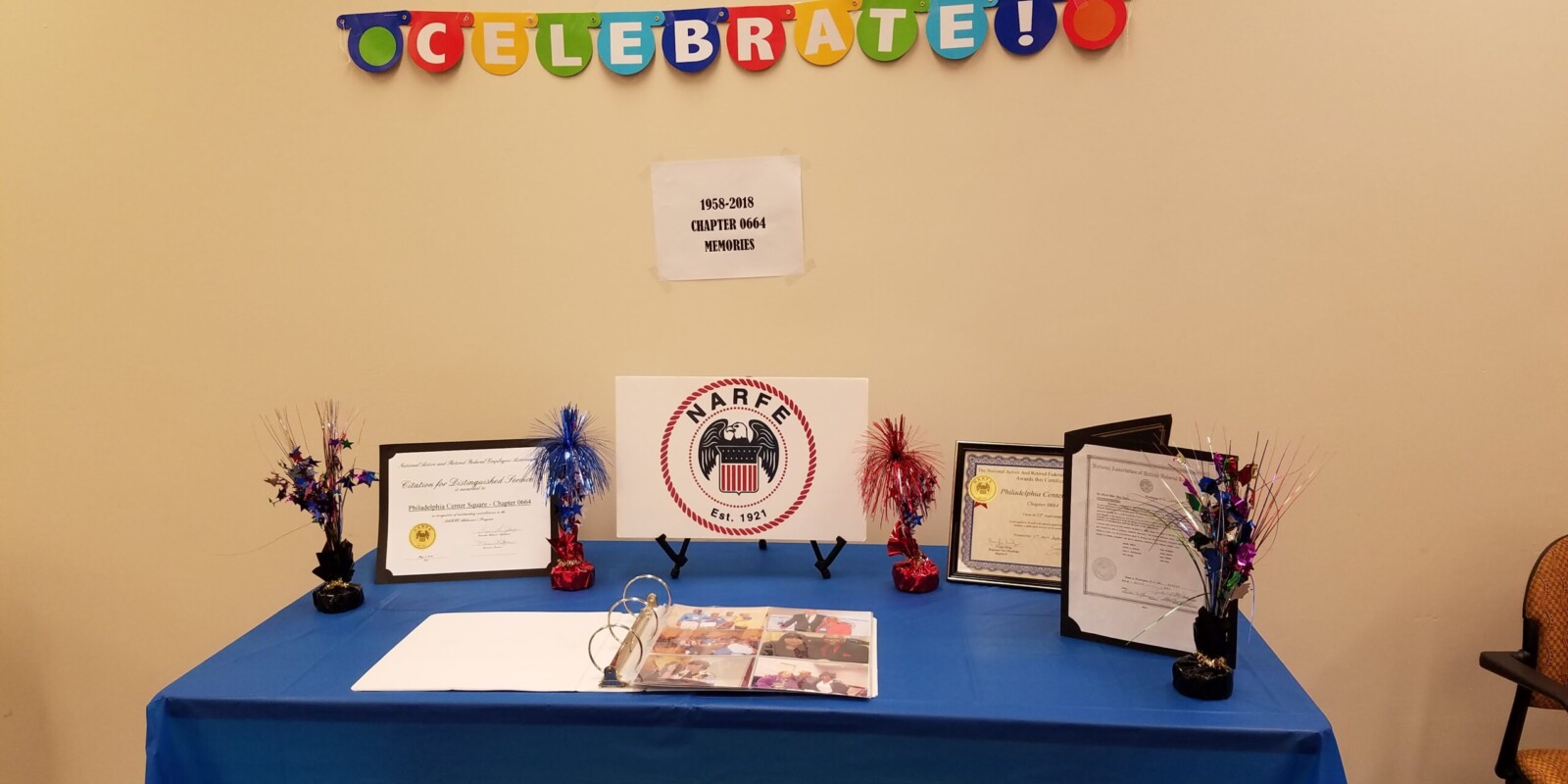 Table displaying Certificates and Photo Album at 60th Anniversary Celebration