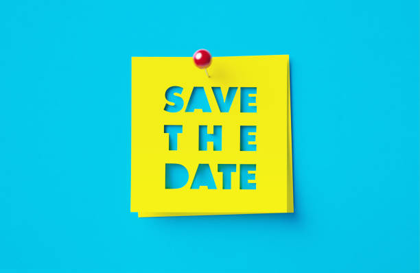 Save the date written cut out yellow adhesive notes sitting on blue background. Horizontal composition with copy space.