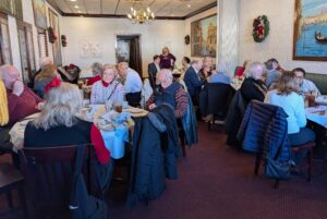 Photograph of a group of 30 members sitting at tables