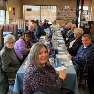 Group of people sitting at restaurant table.