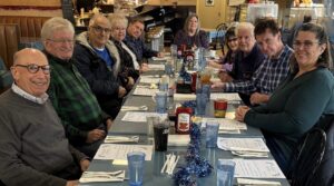 Group of people sitting a lunch table.