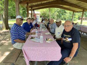 chapter members seated around a long picnic table