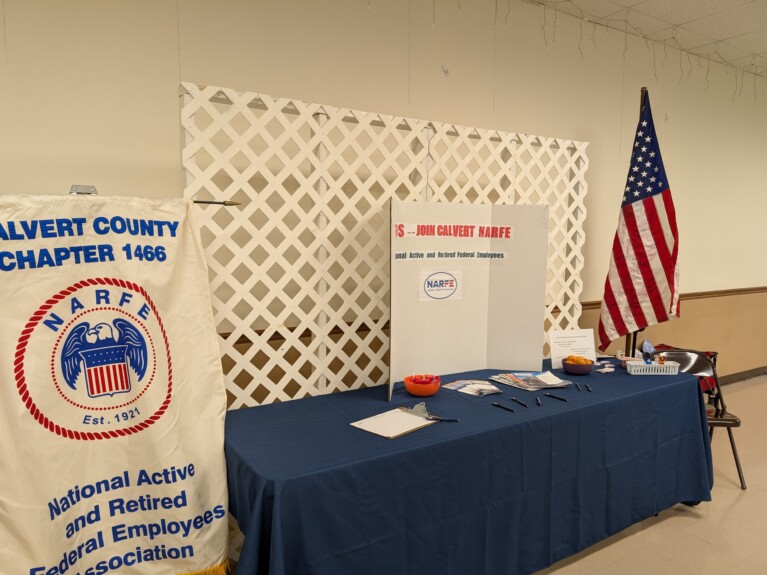 NARFE Banner next to table containing handouts with poster and US flag on side