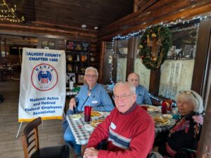 Multiple people gathered around a table with chapter banner
