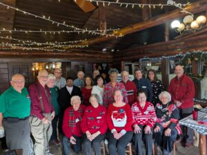 Multiple people gathered around at our Holiday Luncheon