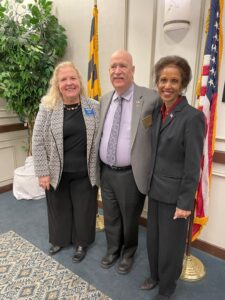 3 people in front of the Maryland and US flags