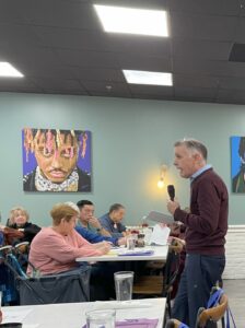 man speaking to a room of seniors in a restaurant