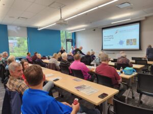 Classroom of adults facing screen with opening slide of Navigating Local Aging Services presentation