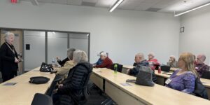 woman speaking in front of a classroom of adults