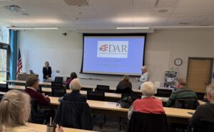 Women in front of a classroom overhead screen
