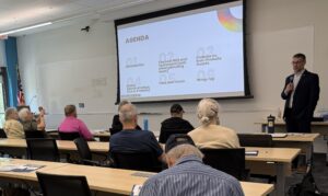 man in front of classroom with agenda on screen