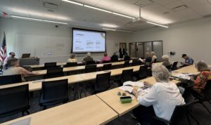 man in front of classroom with agenda on screen