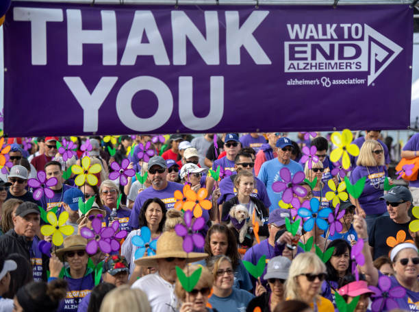 Large group holding flowers while walking