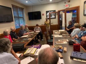 Guest standing and giving a briefing to chapter members seated at tables
