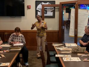Guest standing giving speech to chapter members seated at tables