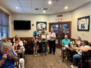 Chapter president, member, and florida federation president standing in front of chapter members after certificate presentation