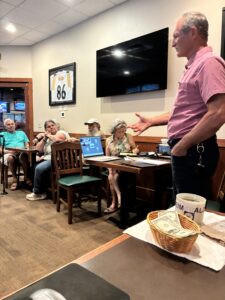 Dave Hartzell standing in front of chapter members and speaking about fraud