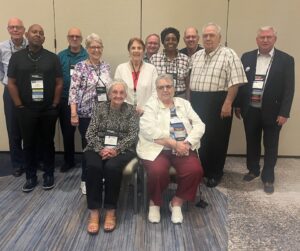 two ladies seated and nine others standing behind them