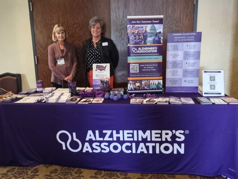 Two Alzheimer Representatives standing by the display table