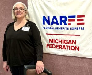 One Chapter members standing in front of banner on a wall