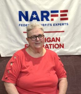 One Chapter member sitting in front of banner on a wall