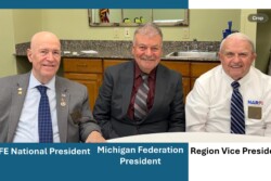 Three men sitting at a table during conference