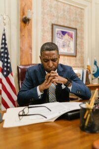 man-at desk-documents-and-flag visible