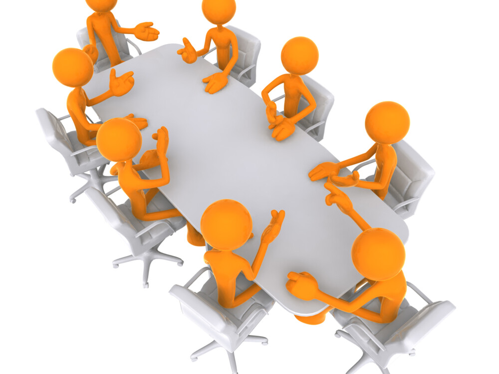 This picture shows cartoon people sitting around a table at a meeting.