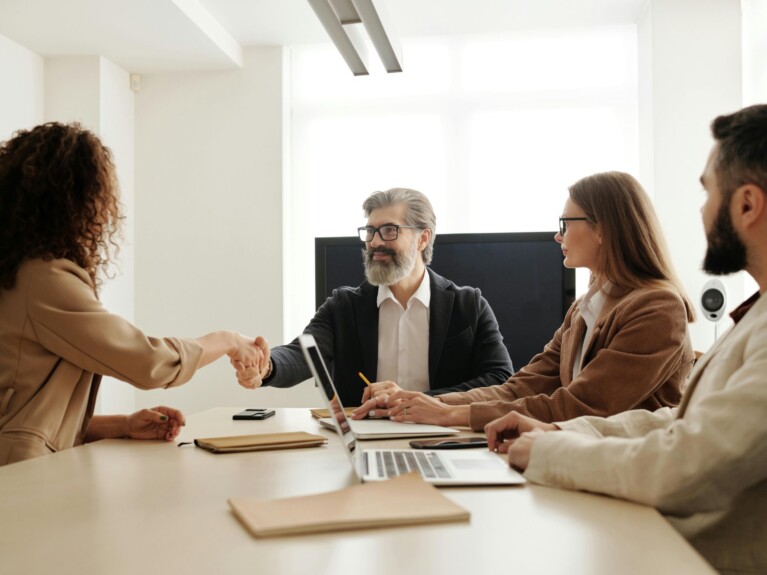 Picture of three people meeting around a conference table.