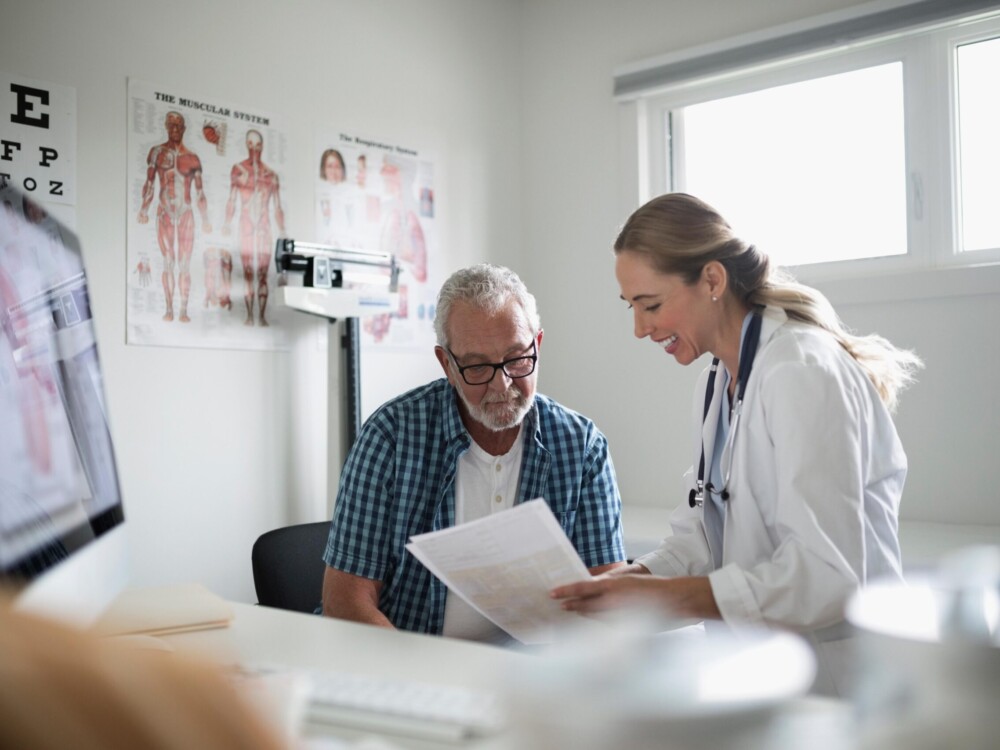 Female doctor talking to male patient in medical office
