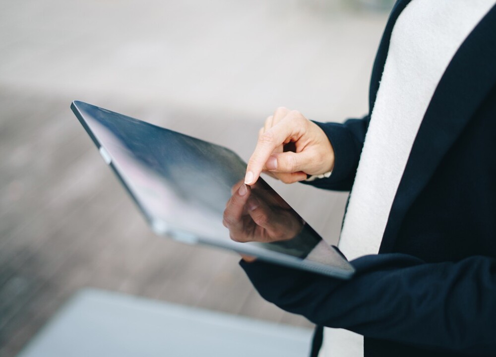 person holding tablet and tapping it with their finger