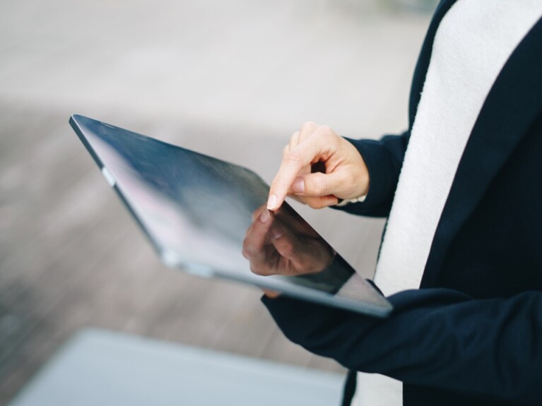 person holding tablet and tapping it with their finger
