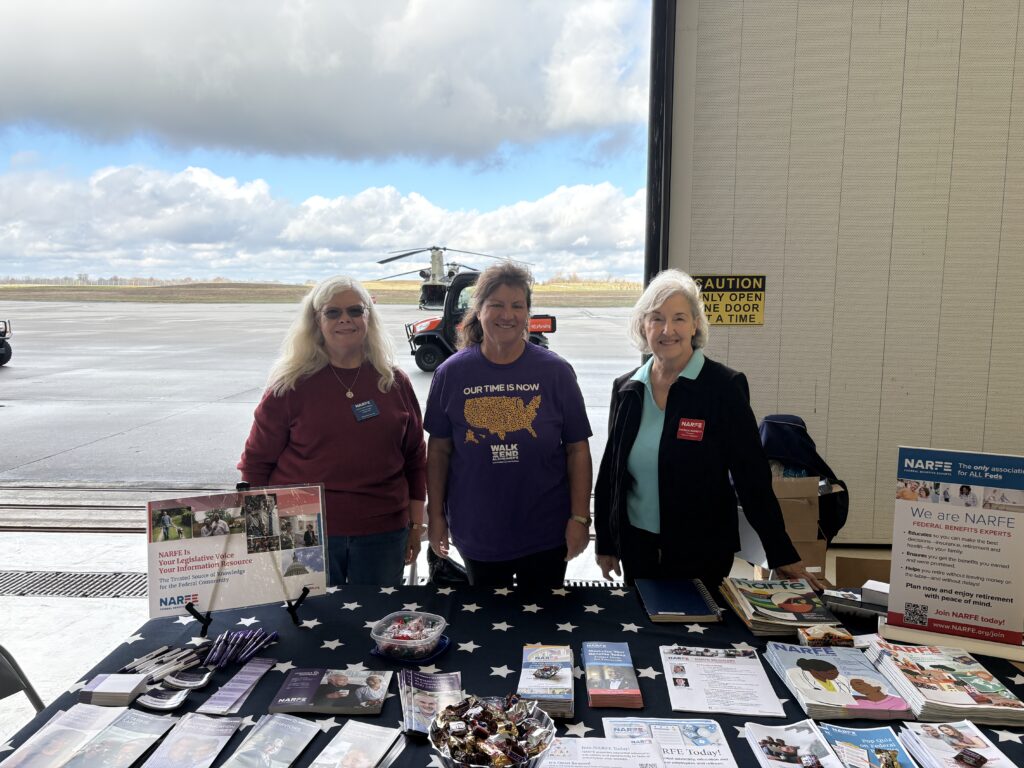 Three NARFE members behind a table containing NARFE informational materials.