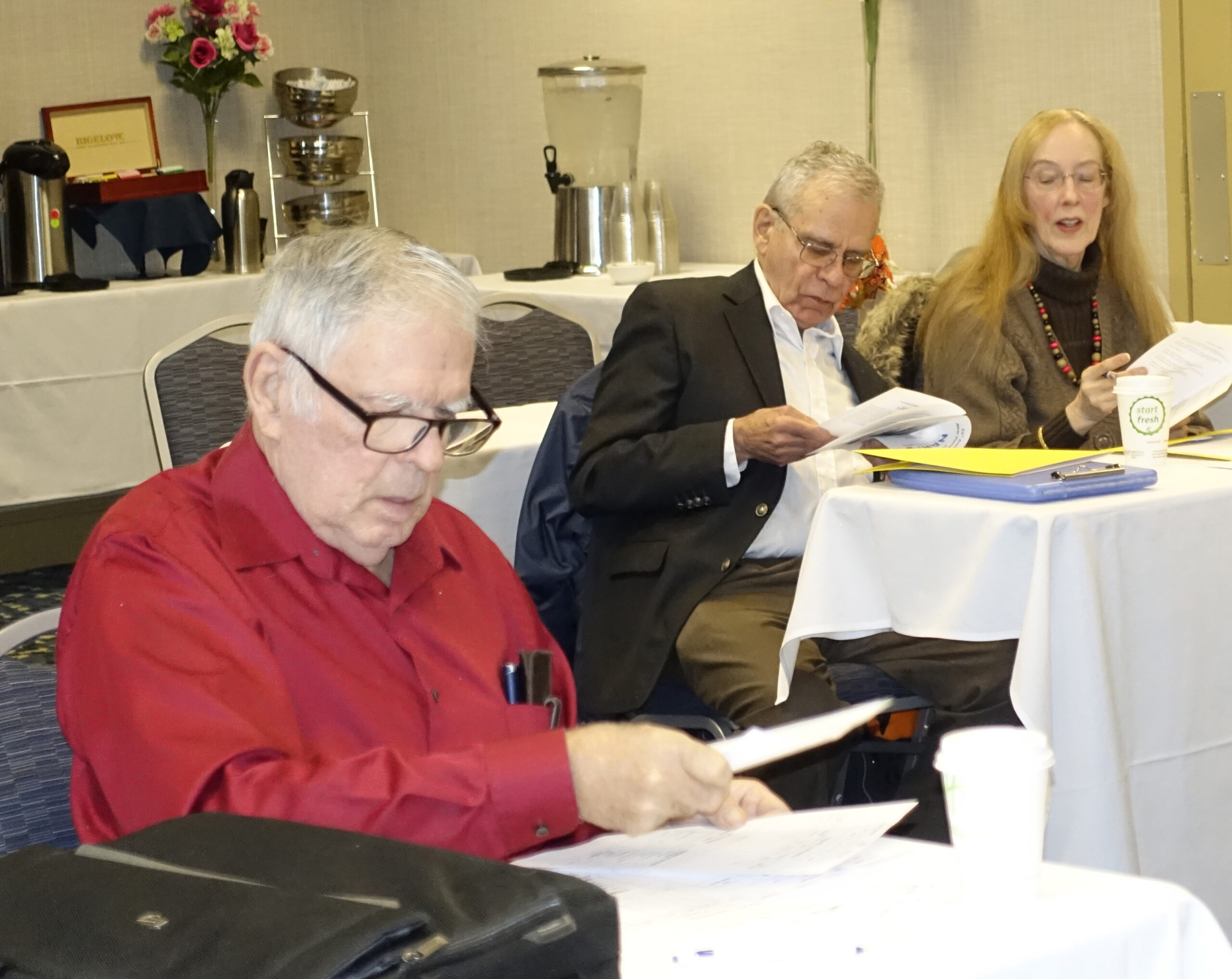 Three people looking at the program